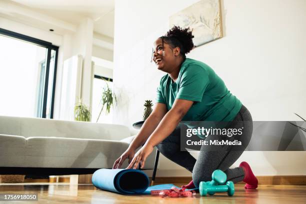 jeune femme faisant de l’exercice à la maison - mannequin grande taille photos et images de collection