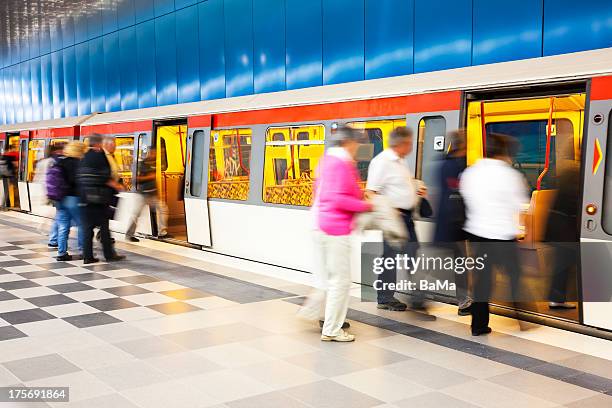 blurred people getting into subway train - metro hamburg stock-fotos und bilder