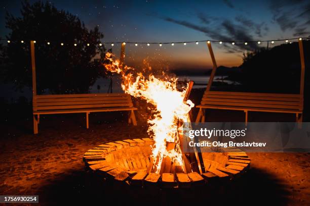 huge campfire on seaside in twilight. place for relaxation in evening. - hoguera de campamento fotografías e imágenes de stock