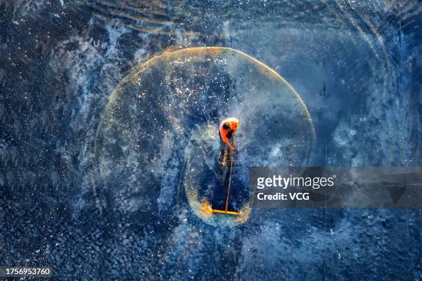 Aerial view of a worker drying salt in a salt pan of Waizhi Island on October 24, 2023 in Ningbo, Zhejiang Province of China.