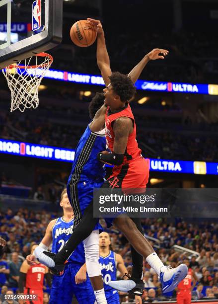 Jalen Green of the Houston Rockets attempts to dunk over Jonathan Isaac of the Orlando Magic during the opening night game at Amway Center on October...