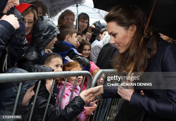 Kate Middleton, fiancee of Britain's Prince William, shakes hands with well-wishers following a visit with William to Darwen Aldridge Community...