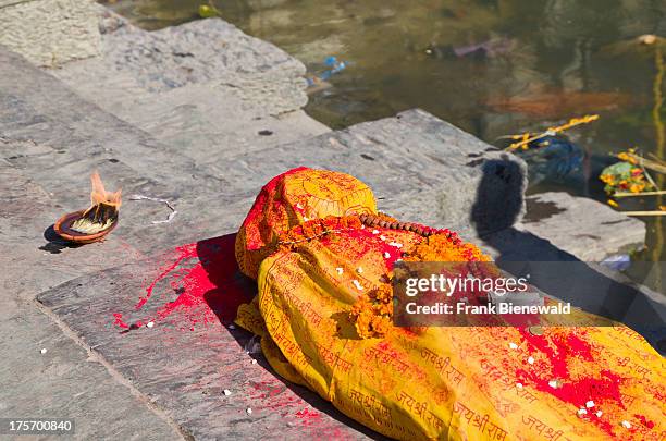 Dead person, wrapped in yellow material, awaiting its cremation at the burning ghats near Pashupatinath Temple..