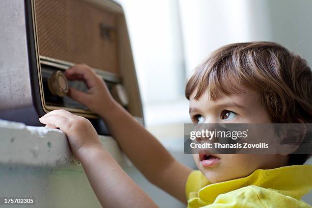 small boy listening music from an old radio - radio listening stock pictures, royalty-free photos & images