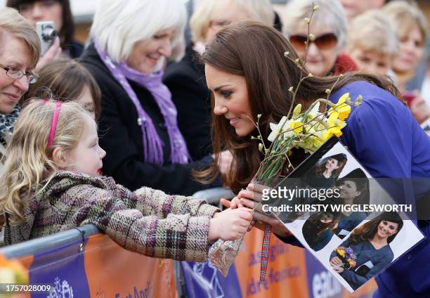 Britain's Catherine, Duchess of Cambridge speaks with a girl in the crowd during a visit to The Treehouse in Ipswich, eastern England, on March 19,...
