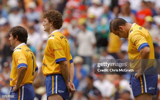 Dolphins players Matt Johns, Brett Mullins and Mark Geyer watch a video tribute to the members of the Dolphins killed in the Bali Bombing before the...