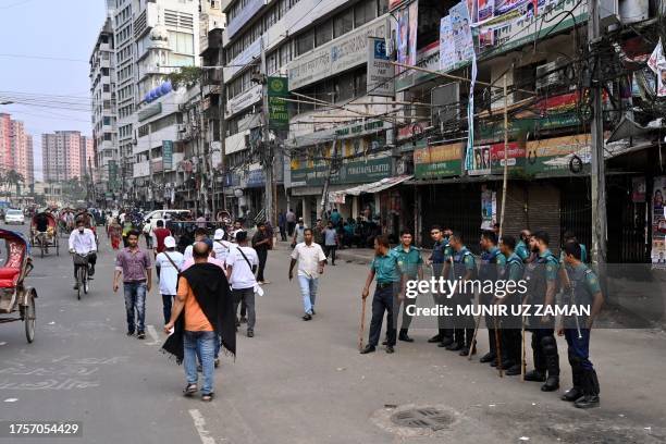 Police personnel stand guard in front of the Bangladesh Nationalist Party headquarters in Dhaka on November 1 during a nationwide strike called by...