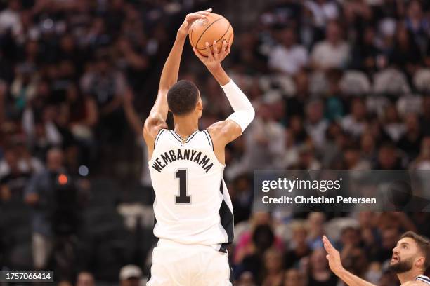 Victor Wembanyama of the San Antonio Spurs shoots a three point basket to score his first points in the NBA during the first quarter against the...