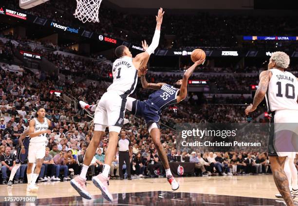 Victor Wembanyama of the San Antonio Spurs defends against Derrick Jones Jr. #55 of the Dallas Mavericks during the first quarter at Frost Bank...