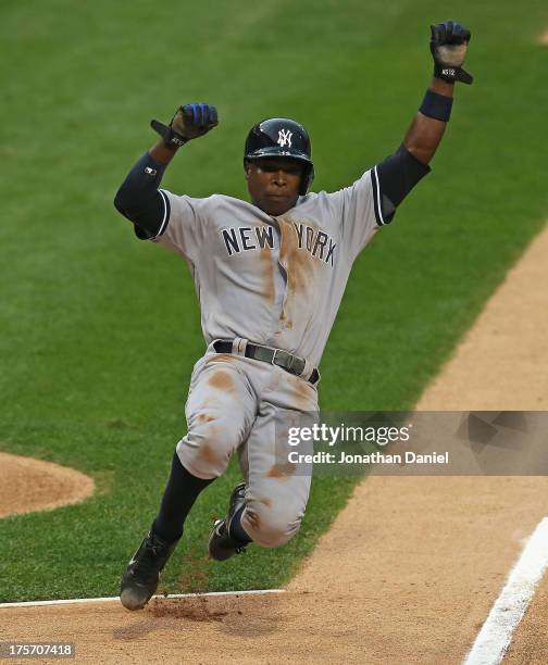 Alfonso Soriano of the New York Yankees slides into home to score a run on a wild pitch in the 1st inning against the Chicago White Sox at U.S....