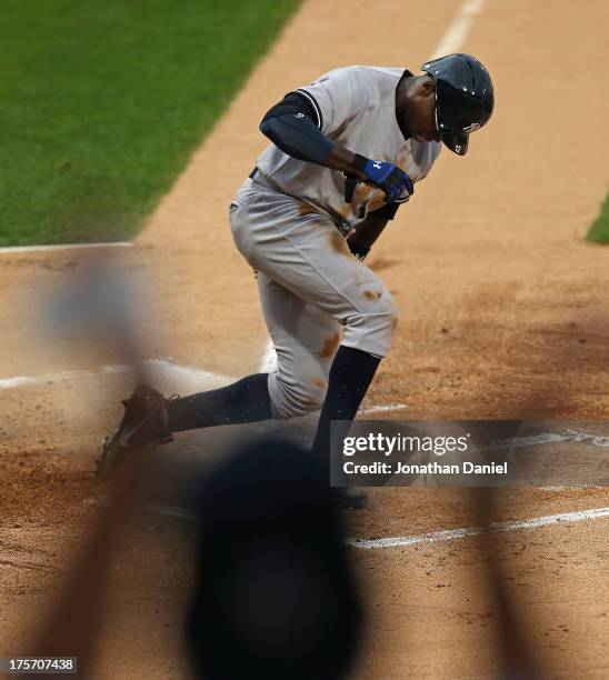 Fan cheers as Alfonso Soriano of the New York Yankees scores a run on a wild pitch in the 1st inning against the Chicago White Sox at U.S. Cellular...