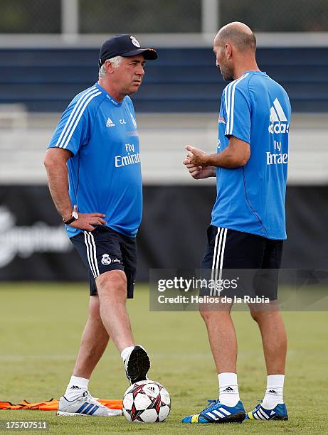 Head coach Carlo Ancelotti of Real Madrid speaks with assistant Zinedine Zidane during a training session at Barry University on August 6, 2013 in...