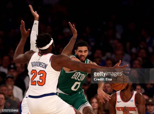 Jayson Tatum of the Boston Celtics passes as Mitchell Robinson of the New York Knicks defends at Madison Square Garden on October 25, 2023 in New...