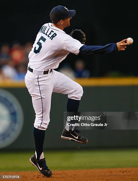 Shortstop Brad Miller of the Seattle Mariners makes an errant throw to second allowing Colby Rasmus of the Toronto Blue Jays to advance to 3rd on a...