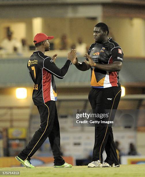 Rahkeem Cornwall gets a high-five from his captain Marlon Samuels of Antigua Hawksbills during the Eighth Match of the Caribbean Premier League...
