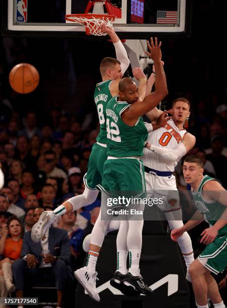 Donte DiVincenzo of the New York Knicks passes as Kristaps Porzingis and Al Horford of the Boston Celtics defend in the first quarter at Madison...