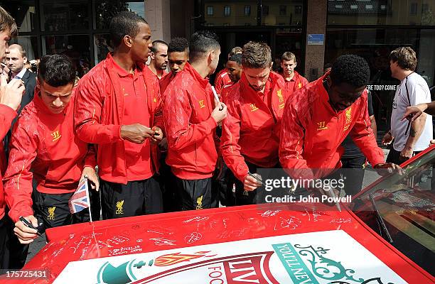Kolo Toure, Oussama Assaidi and Fabio Borini, Andre Wisdom and Philippe Coutinho of Liverpool autographs a car decorated by Liverpool fan Jan Erik...