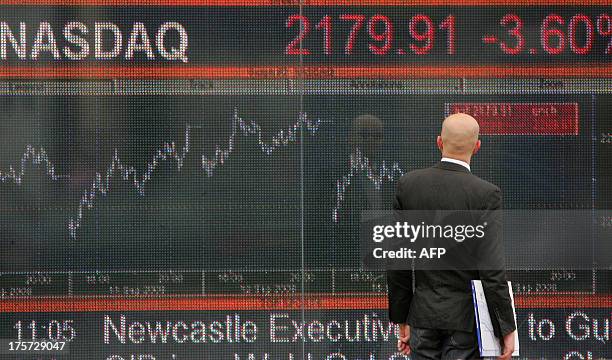 Man looks at an electronic screen in west London which shows the falling NASDAQ index on September 16, 2008. World equities plunged for a second day...