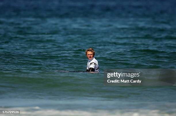 Angus Scotney of Great Britainlooks back towards the beach as he waits for a wave in a very calm sea as he competes in a pro-juniors heat of the...