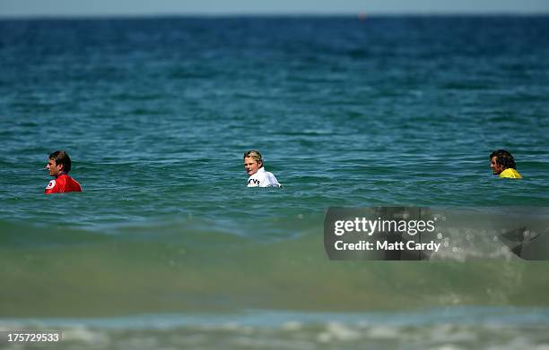 Angus Scotney of Great Britain looks back towards the beach as he waits with fellow competitors for a wave in a very calm sea as he competes in a...