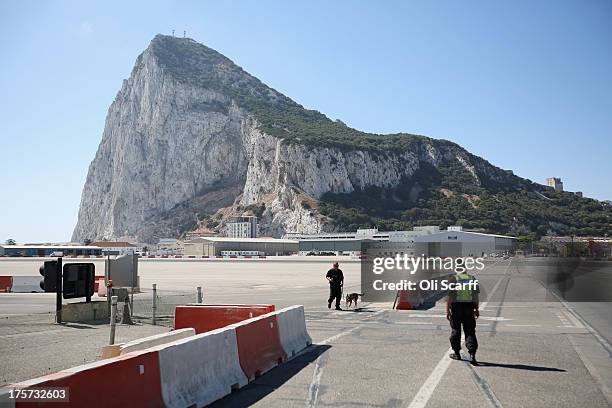 Police officers patrol the footpath which crosses Gibraltar's runway on August 7, 2013 in Gibraltar. Following talks between British Prime Minister...