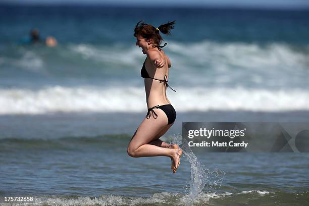 Woman jumps in the sea as the Boardmasters pro-surfing competition takes place on Fistral Beach on August 7, 2013 in Newquay, England. Since 1981,...