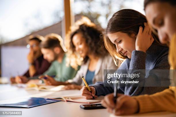 étudiant souriant écrivant pendant un cours à l’université. - étudier photos et images de collection