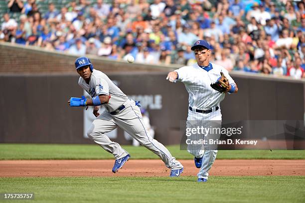 Yasiel Puig of the Los Angeles Dodgers runs to second base as second baseman Darwin Barney of the Chicago Cubs throws the ball at Wrigley Field on...