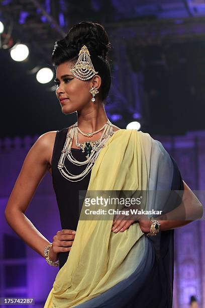 Model walks the runway at the Birdhichand Ghanshyamds Jewellers show on day 4 of India International Jewellery Week 2013 at the Hotel Grand Hyatt on...