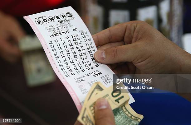 Customer at a 7-Eleven store checks the numbers on his Powerball lottery ticket on August 7, 2013 in Chicago, Illinois. The Powerball jackpot for...