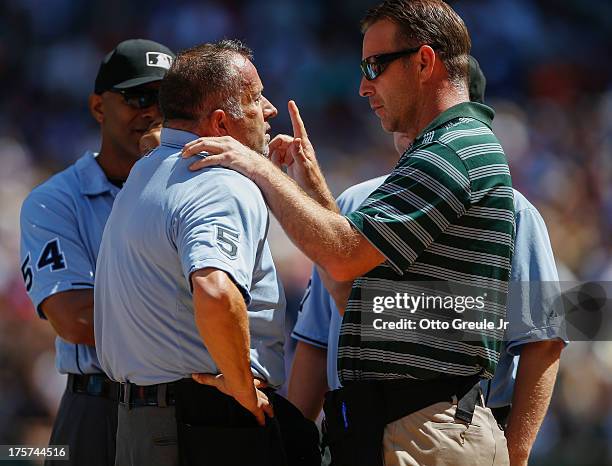 Home plate umpire Dale Scott is examined by trainer Rob Nodine of the Seattle Mariners after he was hit with a foul ball during the game against the...
