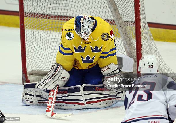 Marcus Hogberg of Team Sweden makes the save on Nic Kerdiles of Team USA during the 2013 USA Hockey Junior Evaluation Camp at the Lake Placid Olympic...