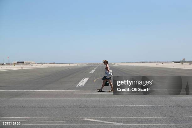 Woman walks along the footpath which crosses Gibraltar's runway on August 7, 2013 in Gibraltar. Following talks between British Prime Minister David...