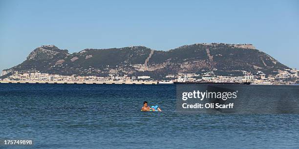 Boy relaxes on a lilo in front of the Rock of Gibraltar on August 7, 2013 in Algeciras, Spain. David Cameron and his Spanish counterpart, Mariano...