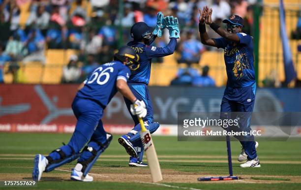 Angelo Matthews of Sri Lanka celebrates the run out wicket of Joe Root of England during the ICC Men's Cricket World Cup India 2023 between England...