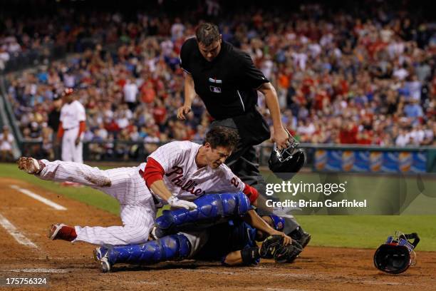 Chase Utley of the Philadelphia Phillies is tagged out as he collides with Dioner Navarro of the Chicago Cubs at the plate in the seventh inning of...