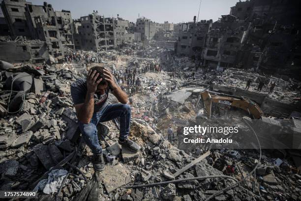 Man, sitting on debris, reacts as Palestinians conduct a search and rescue operation after the second bombardment of the Israeli army in the last 24...