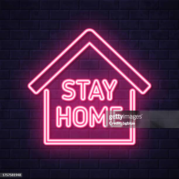 stay home sign. glowing neon icon on brick wall background - brick wall interior stock illustrations