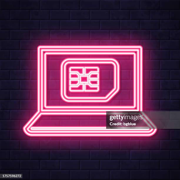 laptop with sim card. glowing neon icon on brick wall background - computer screen close up stock illustrations