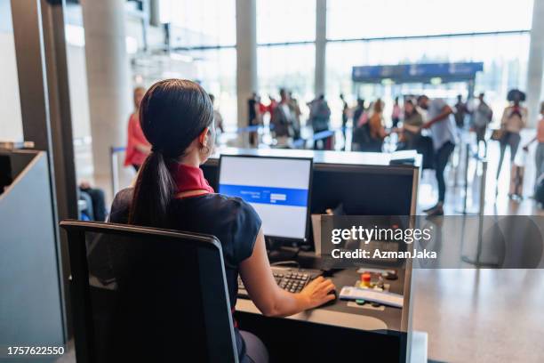 young passenger service agent seated and working on the computer - check in person stock pictures, royalty-free photos & images