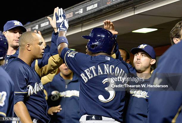 Yuniesky Betancourt of the Milwaukee Brewers is congratulated by teammates after he score on a throwing error by pitcher Madison Bumgarner of the San...