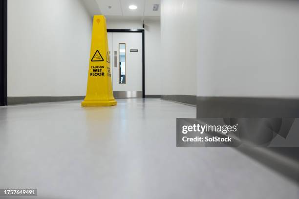 clean hospital corridor - opgepast-gladde-vloer stockfoto's en -beelden