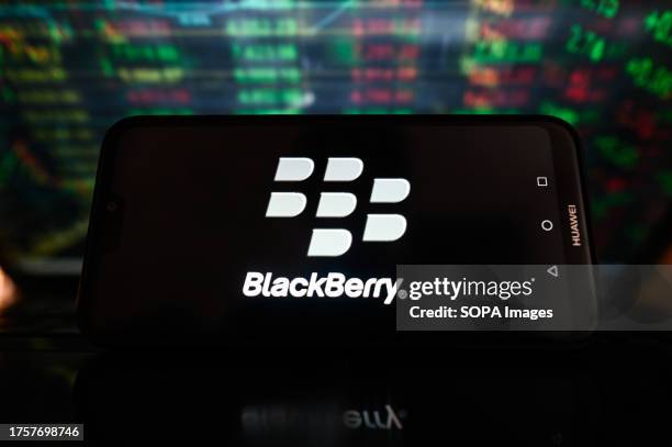 In this photo illustration, a Blackberry logo is displayed on a smartphone with stock market percentages in the background.