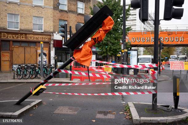 Pedestrian walks across a closed crossing in the aftermath of a collision with a traffic light post at Loughborough Junction, on 1st November 2023,...