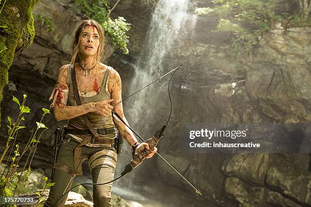 feminino heroína na selva caça com arco e flecha - wounded warrior - fotografias e filmes do acervo