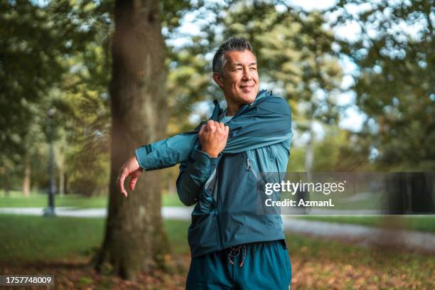 asiatique mâle étirement au parc - fitness photos et images de collection
