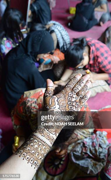 Customer displays her arm styled with mehendi during 'Chand Raat' or 'Night of the Moon' in Hyderabad on August 8 traditionally held on the eve of...