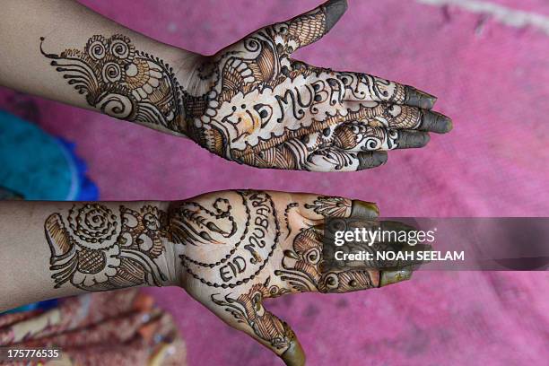 Customer displays her hands styled with mehendi during 'Chand Raat' or 'Night of the Moon' in Hyderabad on August 8 traditionally held on the eve of...
