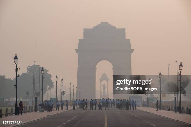 India Gate with visitors seen shrouded in smog during the early morning. Air pollution in Delhi is primarily due to vehicles, industries,...