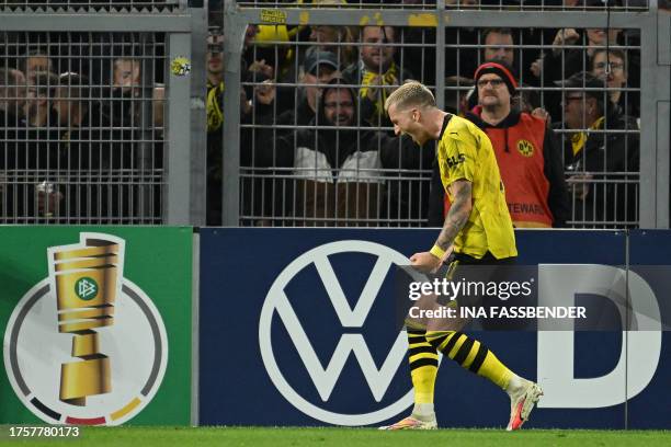 Dortmund's German forward Marco Reus celebrates scoring the opening goal in front of the fans during the German Cup second round football match BVB...